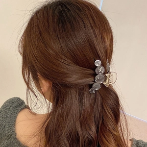 Elegant grey marble acetate round hair claw clip for women shown on deep brown hair