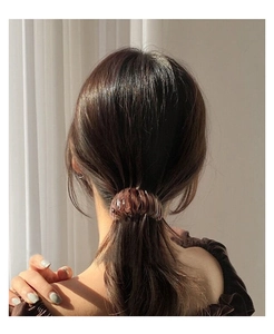Detail view of bird nest hair claw in tortoiseshell brown pattern on a ponytail