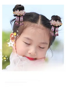 Detail of pink flower hair clips with long beaded tassels on a young girl hairstyle