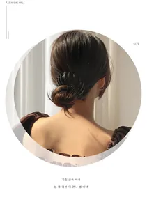 Close-up of a black bird nest hair claw clip styling a bun on a woman's head