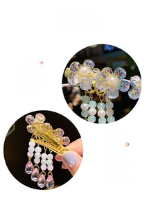 Detailed close-up of a floral hair clip with white pearls and long beaded tassels