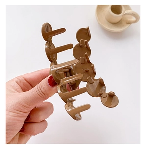 Close-up of a large dark brown hair claw clip with glossy finish and metal spring detail