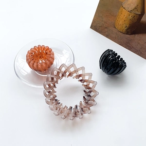 Nesting bird nest hair claw clips in black, amber, and marble brown with expandable design