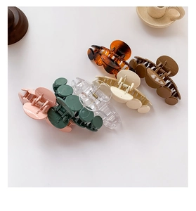 Detailed macro view showing six colorful glossy and translucent minimalist hair claw clips