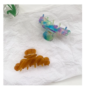 Flat lay of colorful marble and amber acetate hair claws on a clean white background