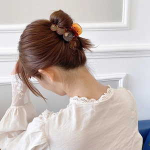 Elegant amber tortoiseshell hair claw clip for women styled in a classic bun hairstyle