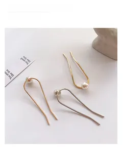 Vue détaillée de trois épingles à cheveux en U en or, or rose et argent avec perles