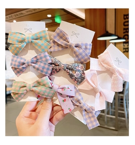 Détails de barrettes à nœuds en tissu aux motifs variés de carreaux et fleurs colorées