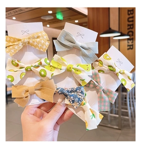 Détail d'un ensemble de barrettes à nœuds en tissu pour filles aux motifs variés