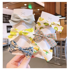 Détail de 6 pinces à cheveux en tissu avec motifs de fleurs et de fruits sur cartes