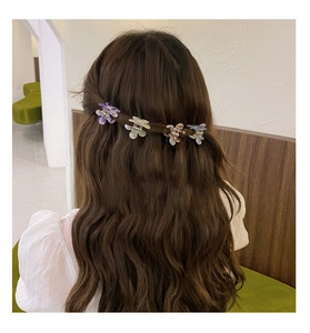 Set of four colorful acetate flower hair clips worn on long wavy brown hair