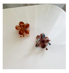 Macro shot of mini flower hair claws in tortoiseshell and blue-purple acetate finish
