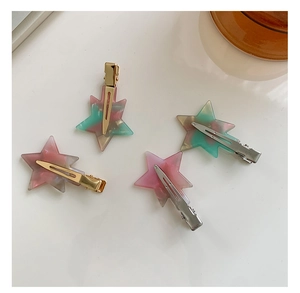 Flat lay of four star-shaped acetate hair clips with pastel marble texture and metal grips