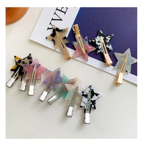 Detailed close-up of acetate star-shaped hair clips with various marble and leopard patterns