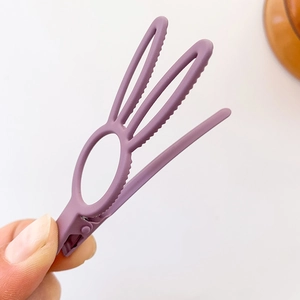 Cute purple bunny ear hair clip with matte finish held against a clean background