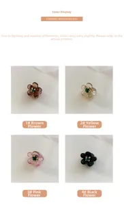 Dettaglio di piccoli fermagli per capelli a camelia in resina con strass multicolore