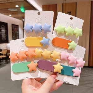 Gros plan de pinces à cheveux étoiles et cœurs colorées aux tons de macarons doux
