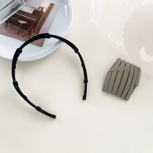 Macro shot of a black toothed headband and a green bird's nest hair clip on a table