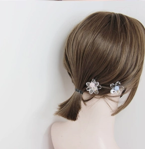 Vista dettagliata di due mollette per capelli a camelia trasparente con strass