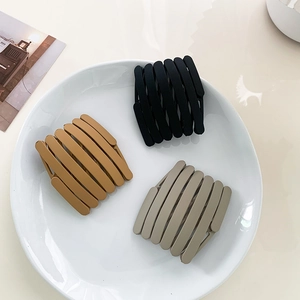 Three-piece frosted folding hair band set in black yellow and khaki on ceramic plate