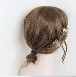 Dettaglio di due mini mollette per capelli a camelia in acrilico con perline colorate