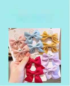 Détail montrant la texture du ruban en satin des jolies pinces à cheveux pour enfants