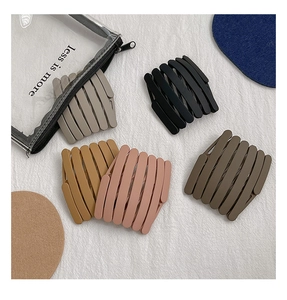 Detailed macro view of retractable matte folding hair bands in multiple neutral colors
