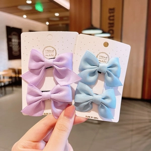 Détail des barrettes nœuds en tissu côtelé faites à la main en violet et bleu ciel