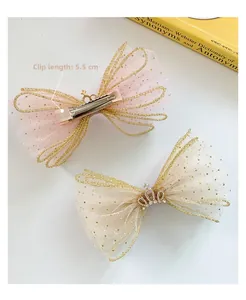 Detail view of 5.5cm kids mesh bow hair clips with gold edging and crown accents