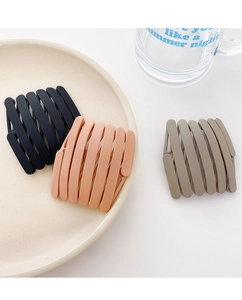 Detail of matte foldable telescopic hairbands in black, pink, and khaki on a tray