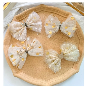 Detail view of 4-piece tulle hair clips set with glitter dots and crown decorations