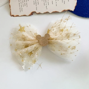 Close-up of white tulle bow clip with gold stars and sequined cartoon mouse motif