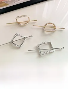 Detail view of gold and silver geometric hair pins with white faux pearl embellishments