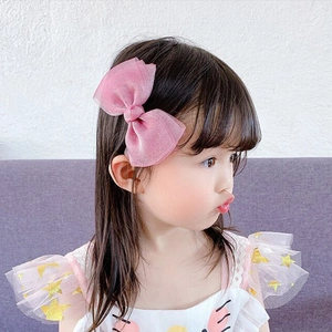 Detail view of the layered pink tulle bow hair clip worn by a young girl