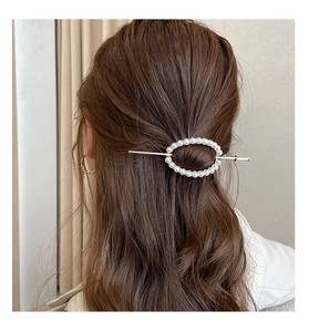 Elegant gold pearl hair stick accessory styled on dark brown wavy hair for women