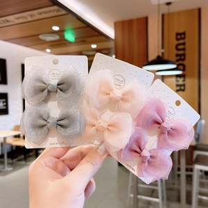Detailed view of handmade mesh bow hair clips in grey, pink, and purple for girls