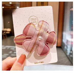 Vue détaillée de la pince à cheveux fleur à carreaux roses avec perle sur carte