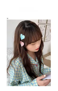 Détail de pinces à cheveux coeur en acétate bleu et rose avec texture marbrée