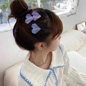 Barrettes à cheveux en acétate en forme de cœur avec motif marbre violet sur un mannequin