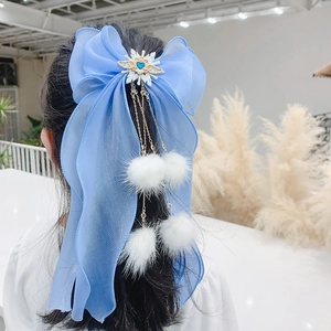 Barrette à nœud en mousseline bleue avec pierre en cœur et pompons de fourrure