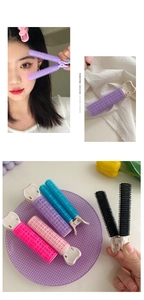 Detail showing colorful hair root clips for volume styling on a lavender tray