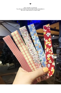Close-up of five patterned fabric bow hairbands in plaid and floral designs