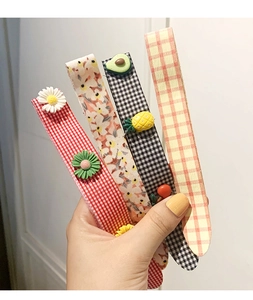Detail of colorful floral and plaid fabric headbands with cute resin fruit and flower charms