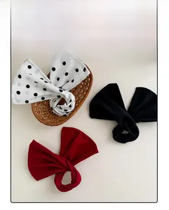 Floral twist hair bun maker showing black polka dot and red fabric patterns in a woven basket