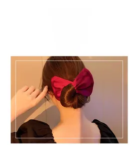 Macro view of a deep wine red silk texture floral magic twister for hair styling