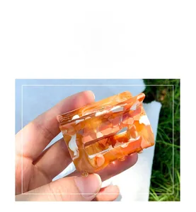 Detail shot of orange ink pattern hair claw clip with semi-transparent resin texture