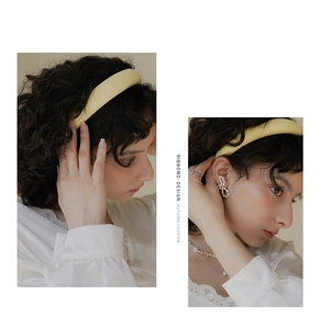 Detailed view of wide yellow sponge headband with matte fabric finish on a female model
