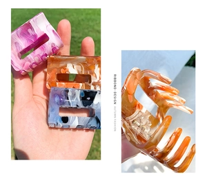 Close-up of hollow rectangular acetate hair claw clips with marble pattern design
