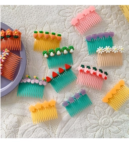 Macro shot of colorful plastic hair side combs with cute cartoon fruits and flowers