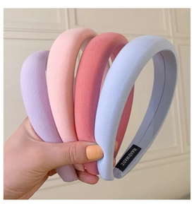 Close-up of thick sponge headbands in macaron colors with handmade woven labels